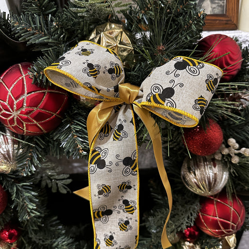 Decorative bow with bee pattern on a Christmas tree with ornaments