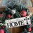 Decorative wreath with 'bless this HOME' sign and Christmas ornaments.