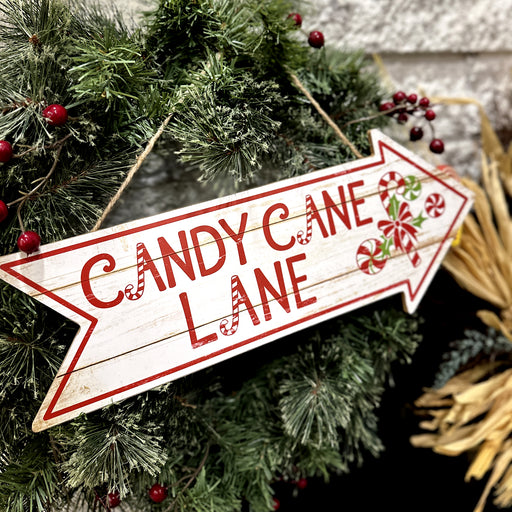 Decorative sign with 'Candy Cane Lane' text on a Christmas wreath.