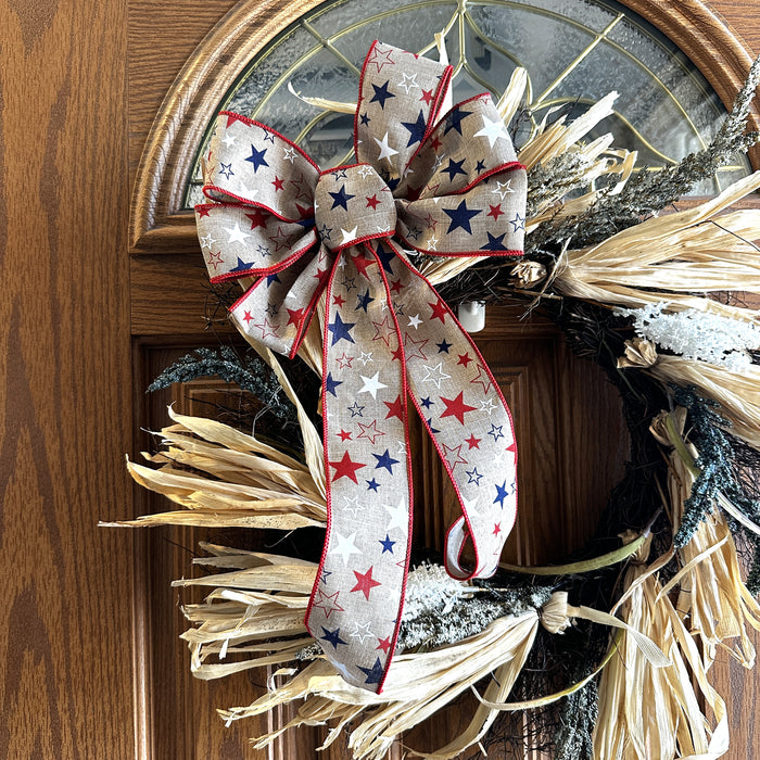 Decorative wreath with a star-themed bow on a wooden door.